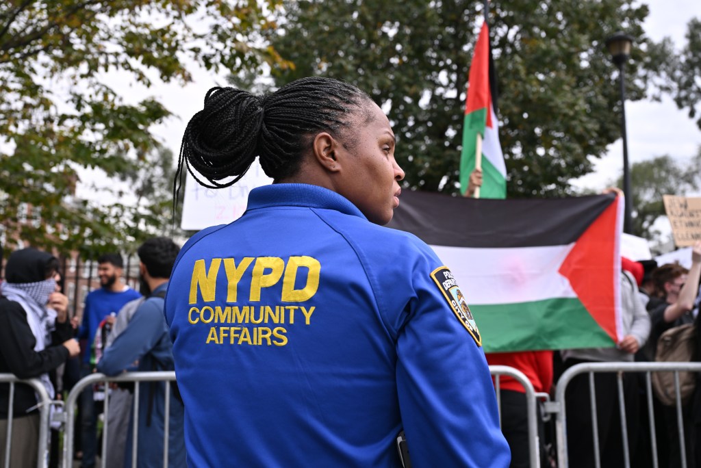 An NYPD officer keeps watch at a pro-Palestinian rally at Brooklyn College on Thursday, ahead of more rallies Friday